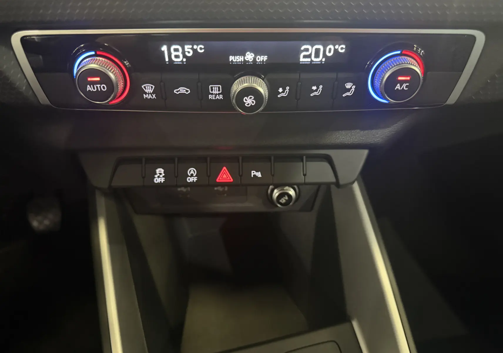 Gros plan sur la console centrale de l'Audi A1 2024, affichant la climatisation bi-zone avec réglages numériques et boutons fonctionnels.