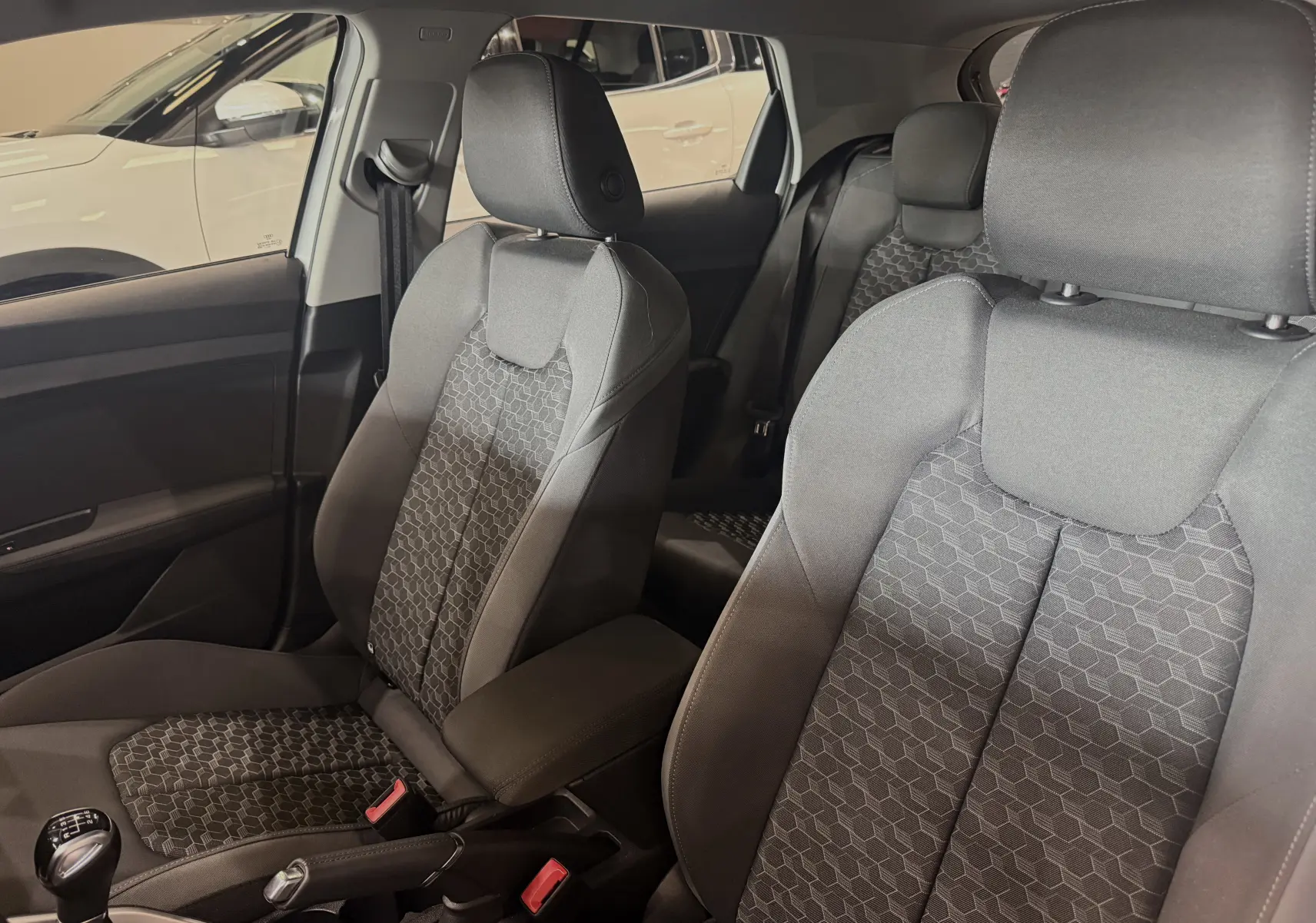 Vue intérieure des sièges avant en tissu gris à motifs hexagonaux de l'Audi A1 30 TFSI S-Line 2024.