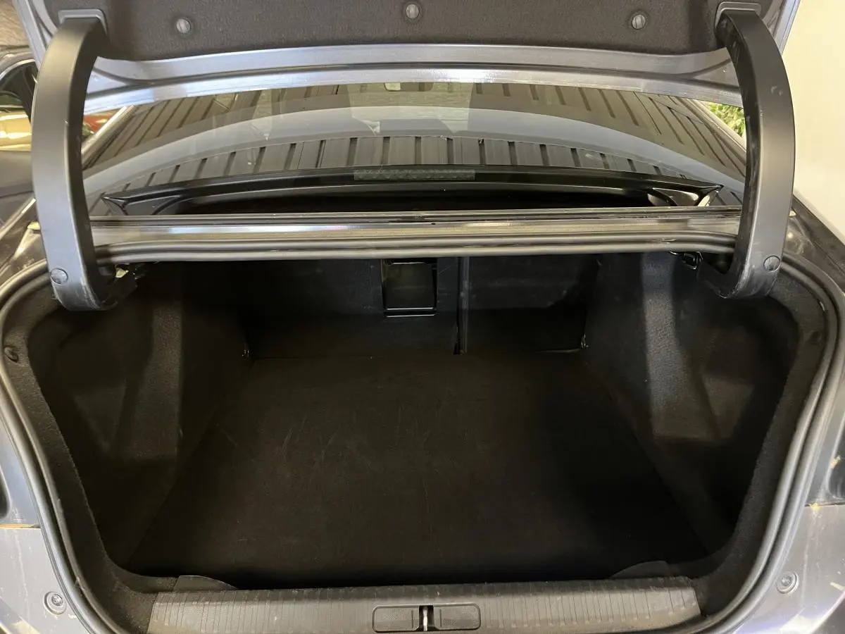 Coffre ouvert d'une Citroën C4 2024 gris métallisé, vue arrière montrant l'espace de chargement vide.