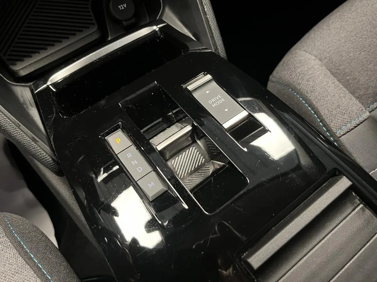 Console centrale noire brillante avec commandes de boîte automatique et mode de conduite sur Citroën C4 gris, vue intérieure rapprochée.