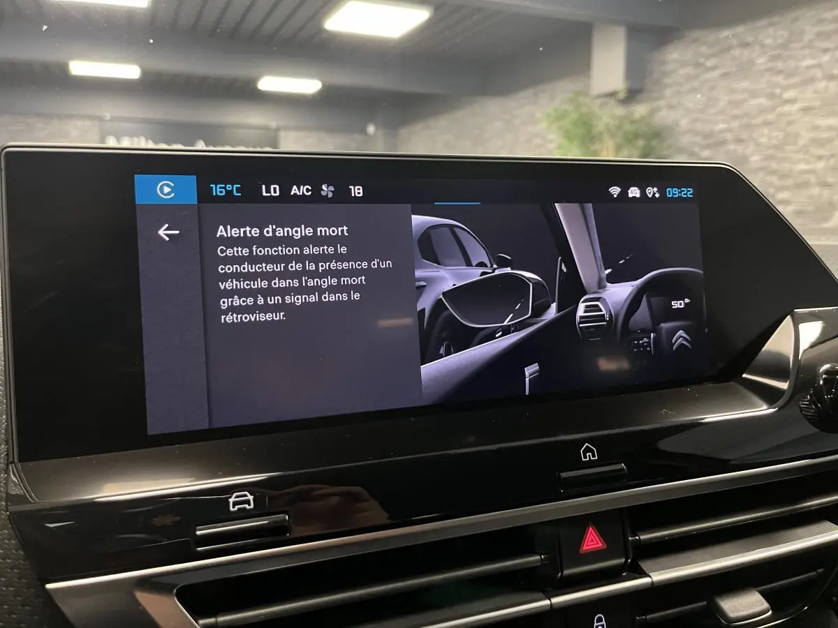 Écran tactile intérieur du Citroën C4 2024 montrant l'alerte d'angle mort avec vue sur rétroviseur côté gauche.