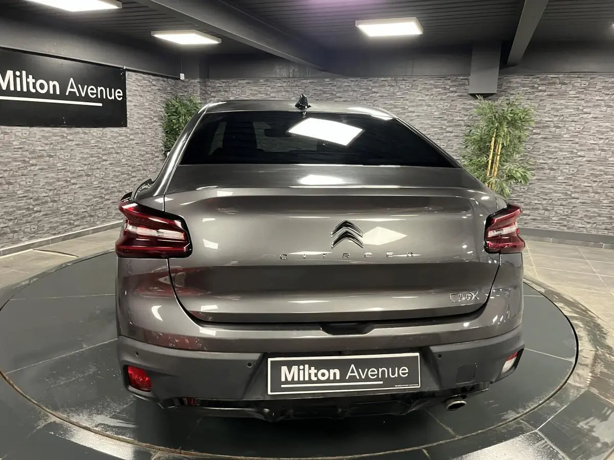 Vue arrière d'une Citroën C4 gris métallisé 2024 avec feux arrière LED et plaque Milton Avenue visible