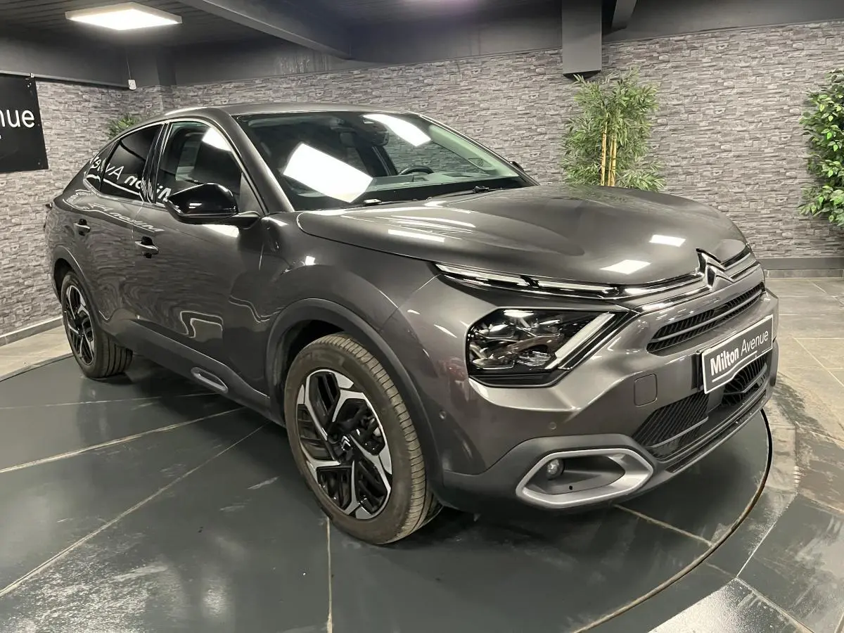 Citroën C4 2024 gris métallisé vue 3/4 avant avec projecteurs LED et jantes alliage 18 pouces.