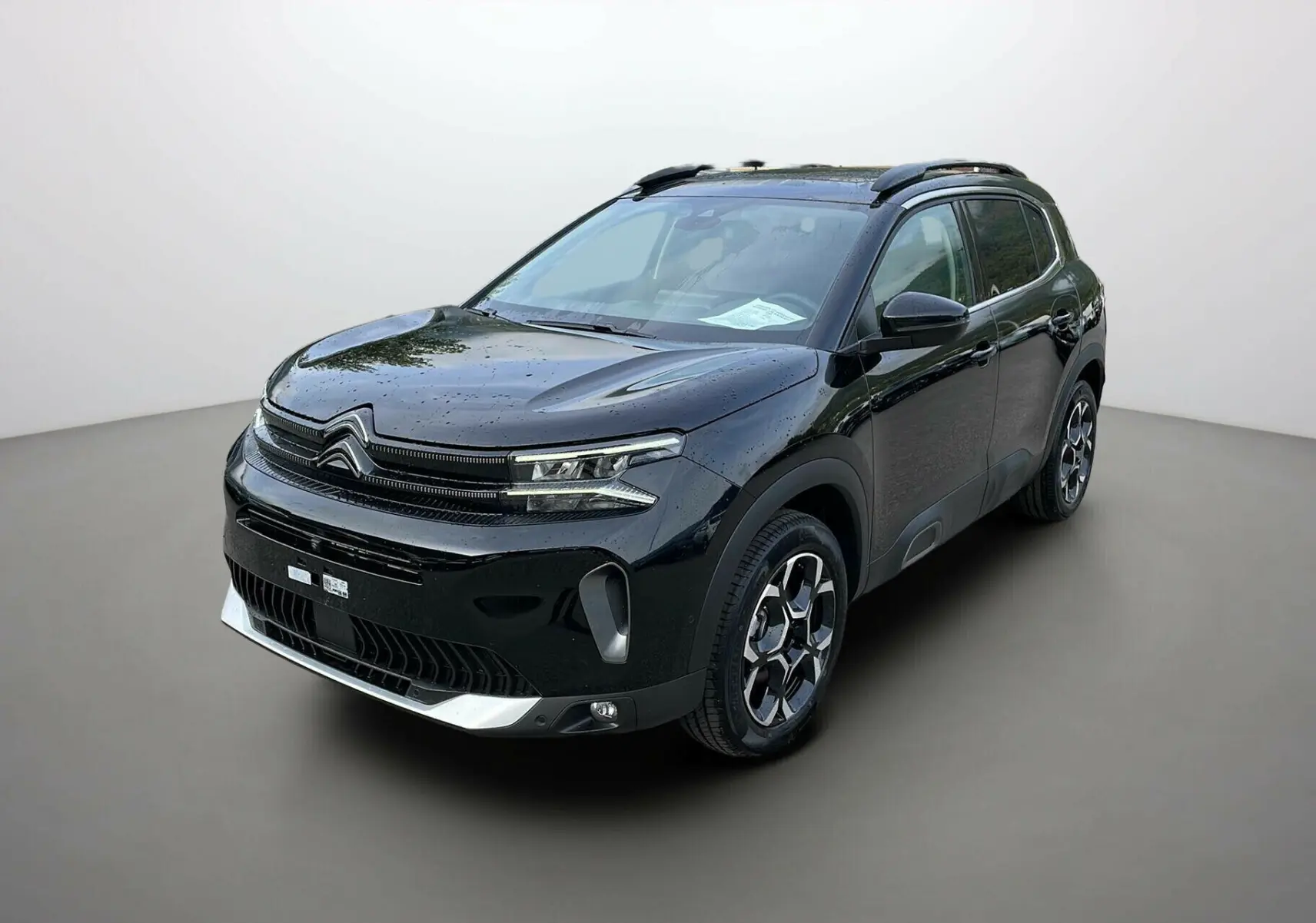 Citroën C5 Aircross Hybrid 2025 noir en 3/4 avant droit avec jantes distinctives et toit ouvrant visible
