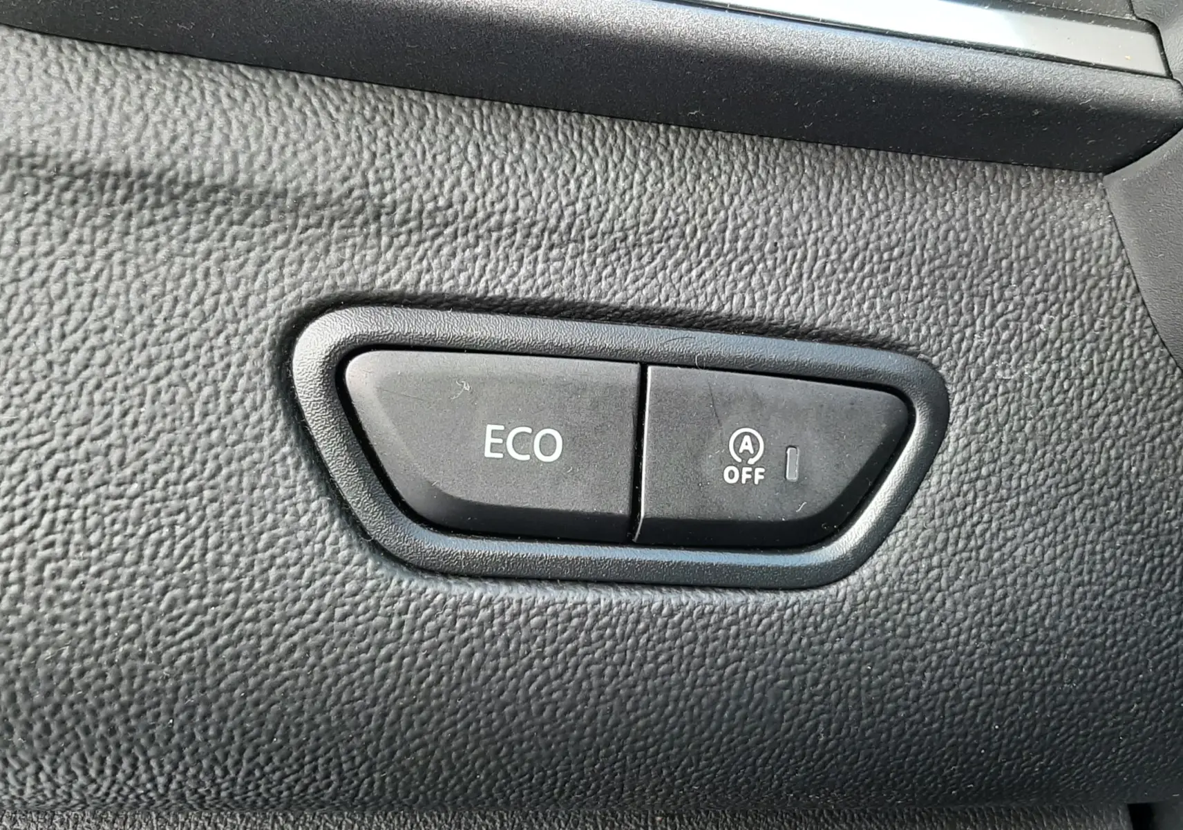 Boutons de commande ECO et arrêt du système start-stop sur tableau de bord noir d'un Renault Kadjar gris 2018.