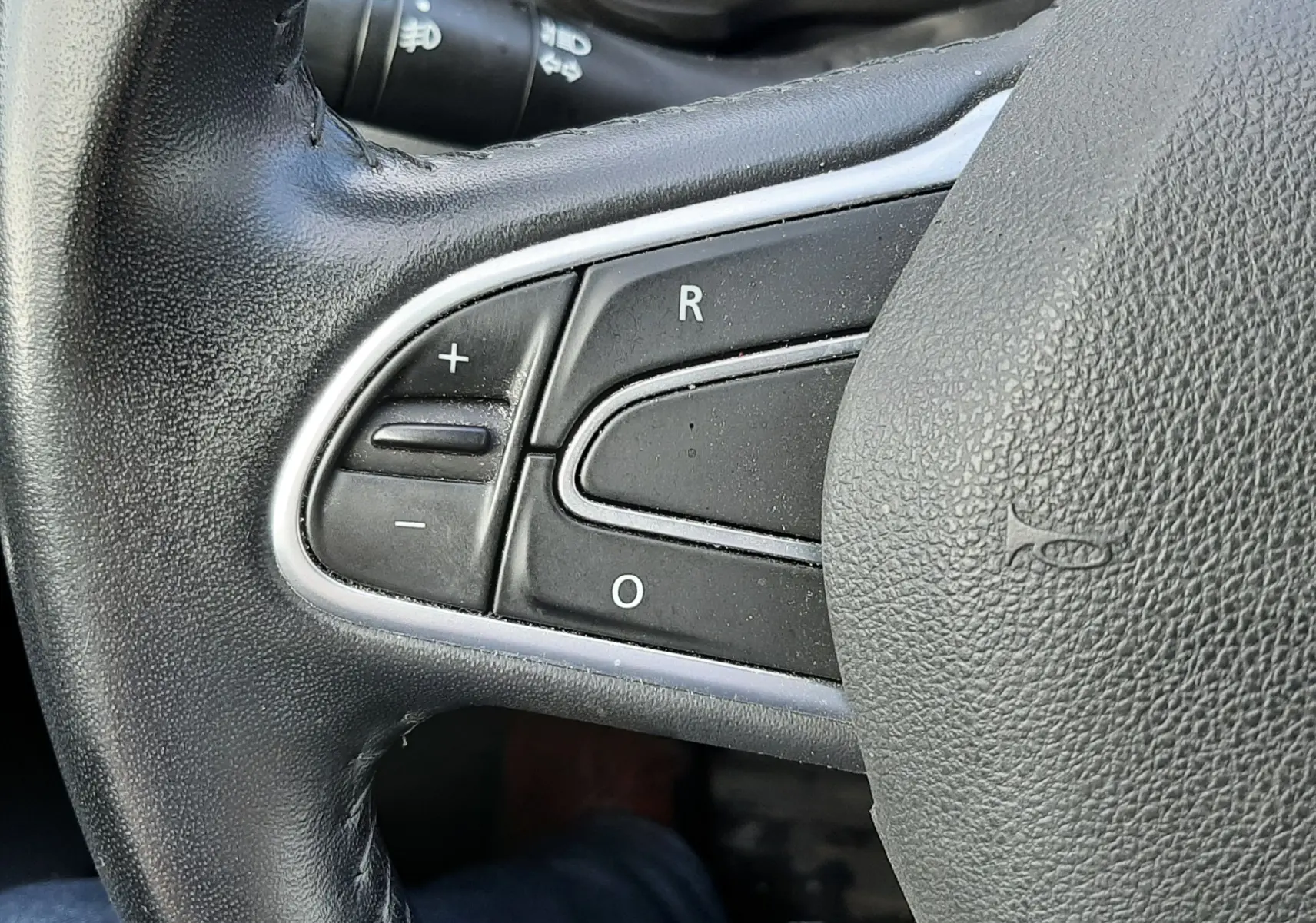Gros plan sur les commandes à gauche du volant en cuir noir du Renault Kadjar gris, modèle 2018 diesel.