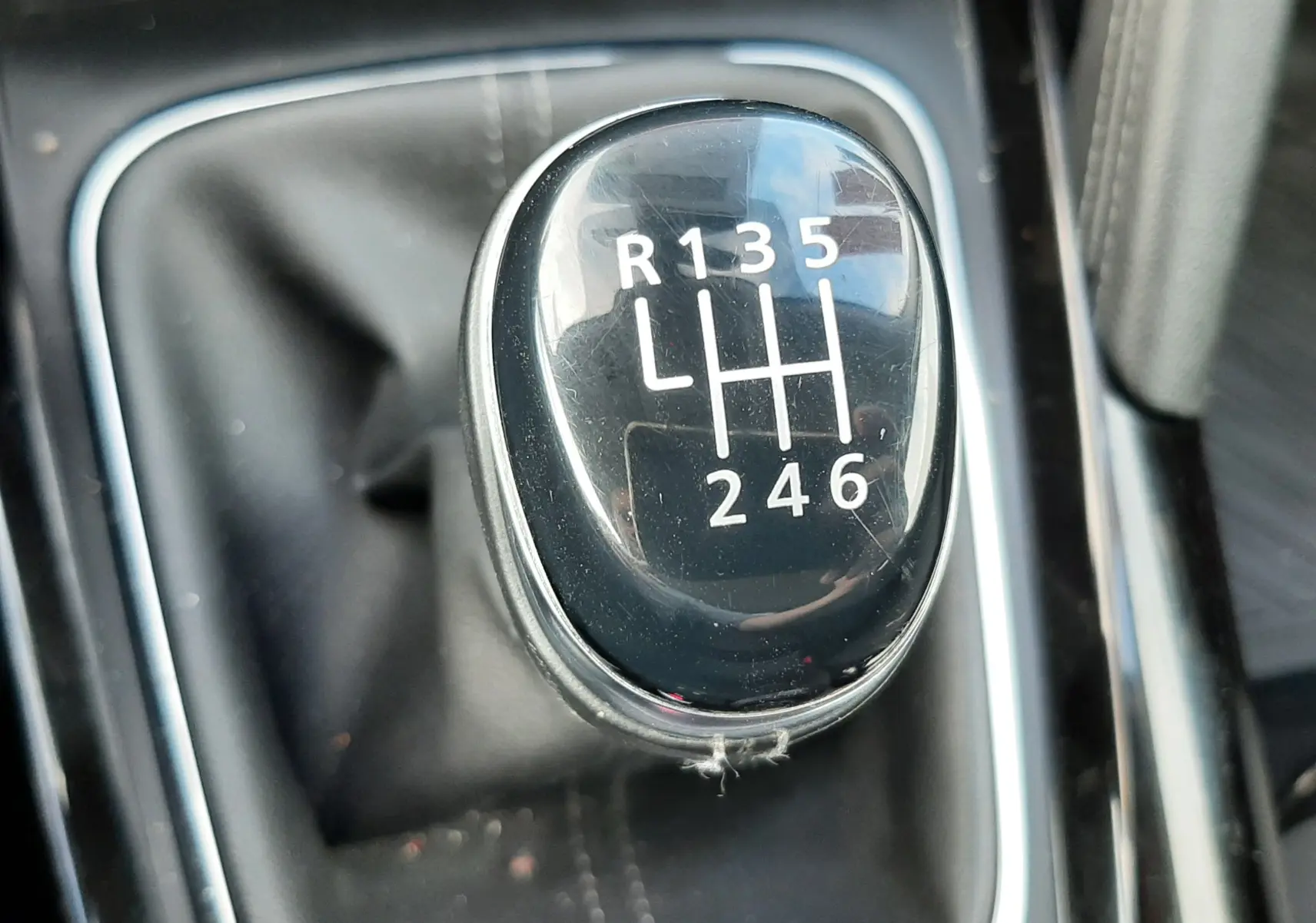 Gros plan sur le levier de vitesses manuel noir du Renault Kadjar gris 2018, montrant les six rapports et la marche arrière.