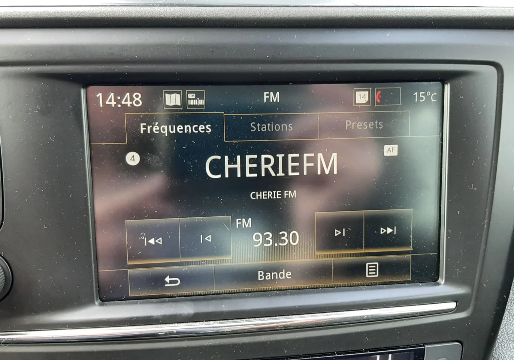 Vue rapprochée de l'écran multimédia et de la climatisation du Renault Kadjar gris, affichant la radio sur CHERIE FM 93.30.