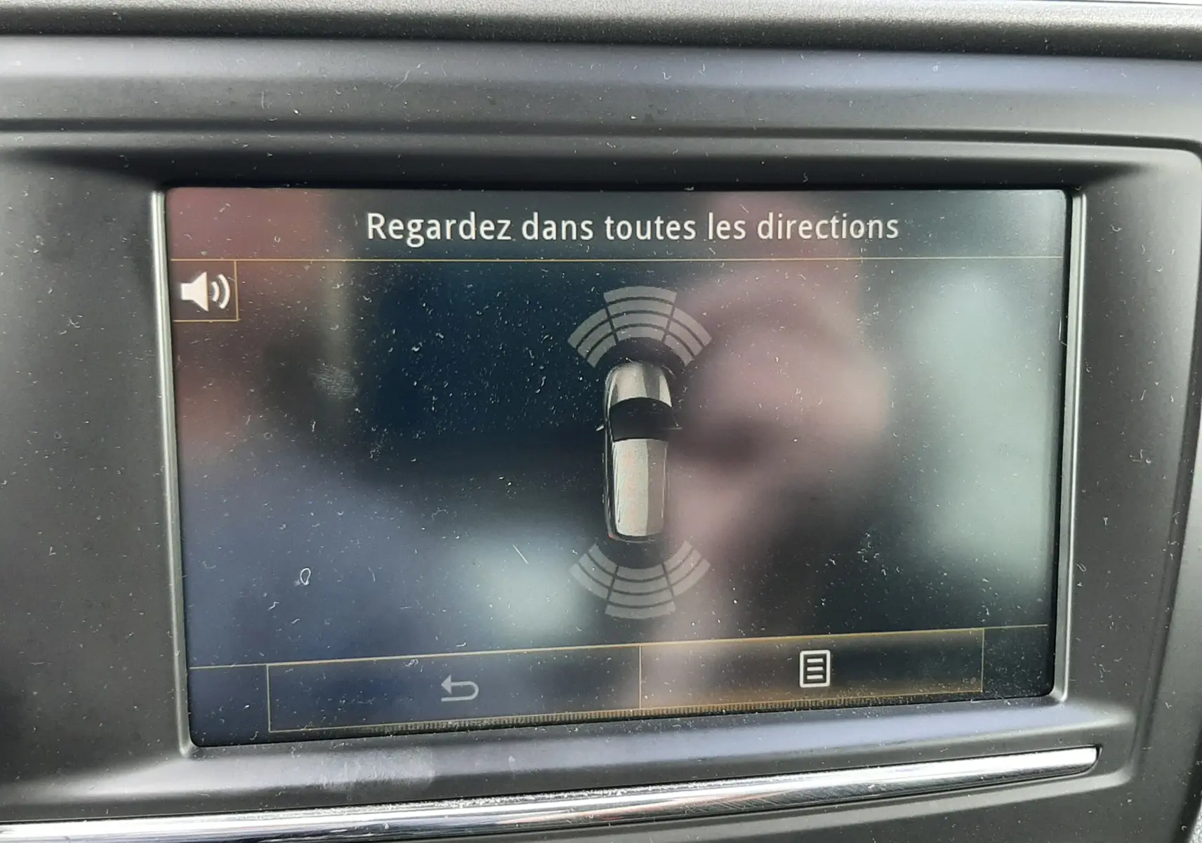 Écran central du tableau de bord du Renault Kadjar gris 2018 affichant l'alerte de surveillance des angles morts.