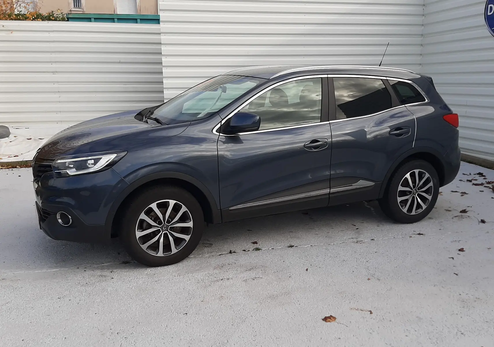 Renault Kadjar gris 2018 vu de profil côté gauche, avec jantes alliage bicolores et lignes fluides.