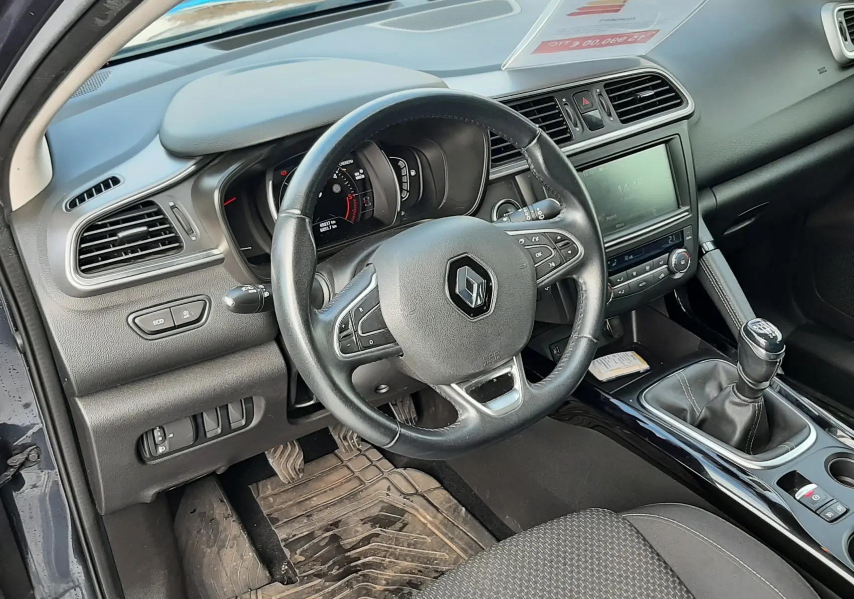 Intérieur côté conducteur du Renault Kadjar gris 2018, volant multifonction, tableau de bord et levier de vitesse manuel visibles.