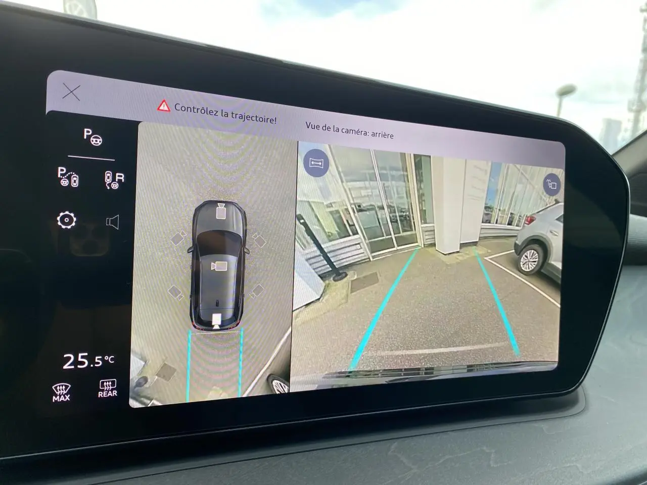 Écran intérieur affichant la caméra 360° et la vue arrière du stationnement d'un Audi Q3 noir mythic métallisé.
