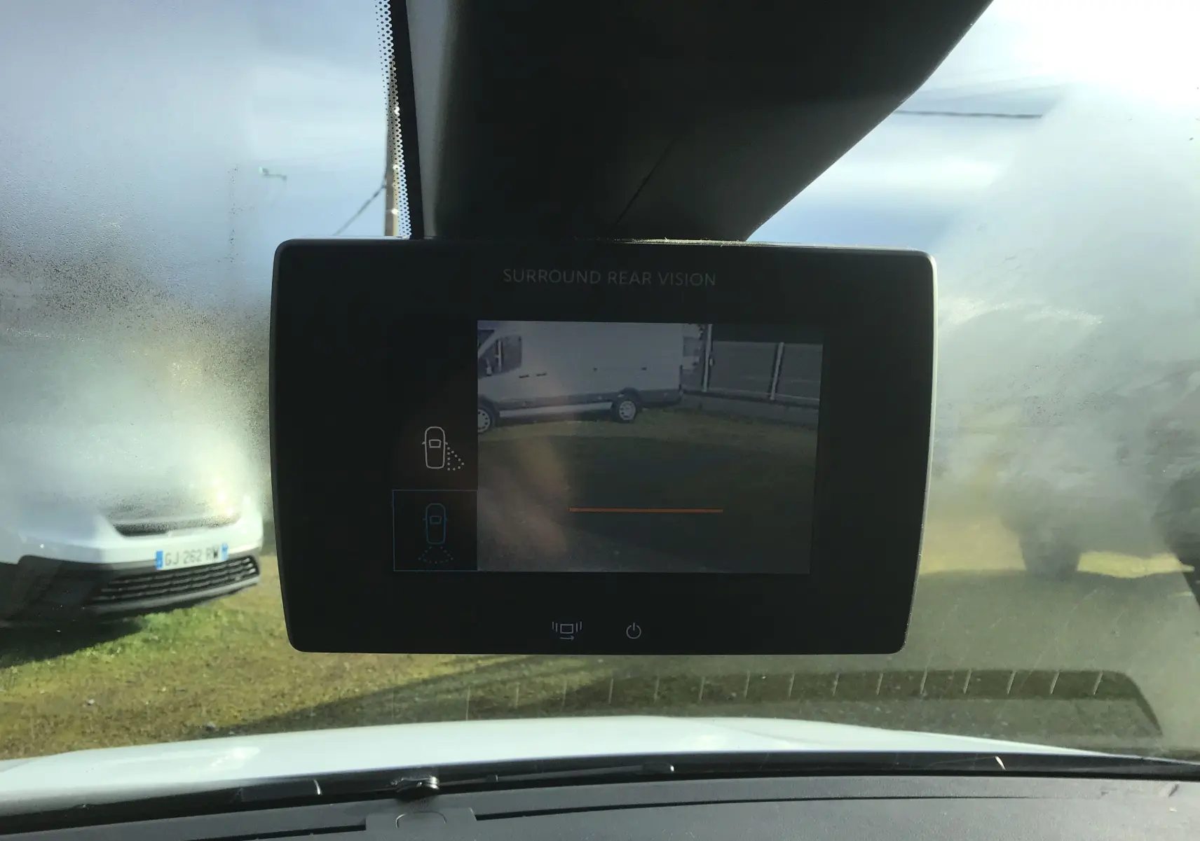 Vue intérieure centrée sur l'écran de caméra de recul du Citroën Berlingo blanc, avec pare-brise partiellement embué.