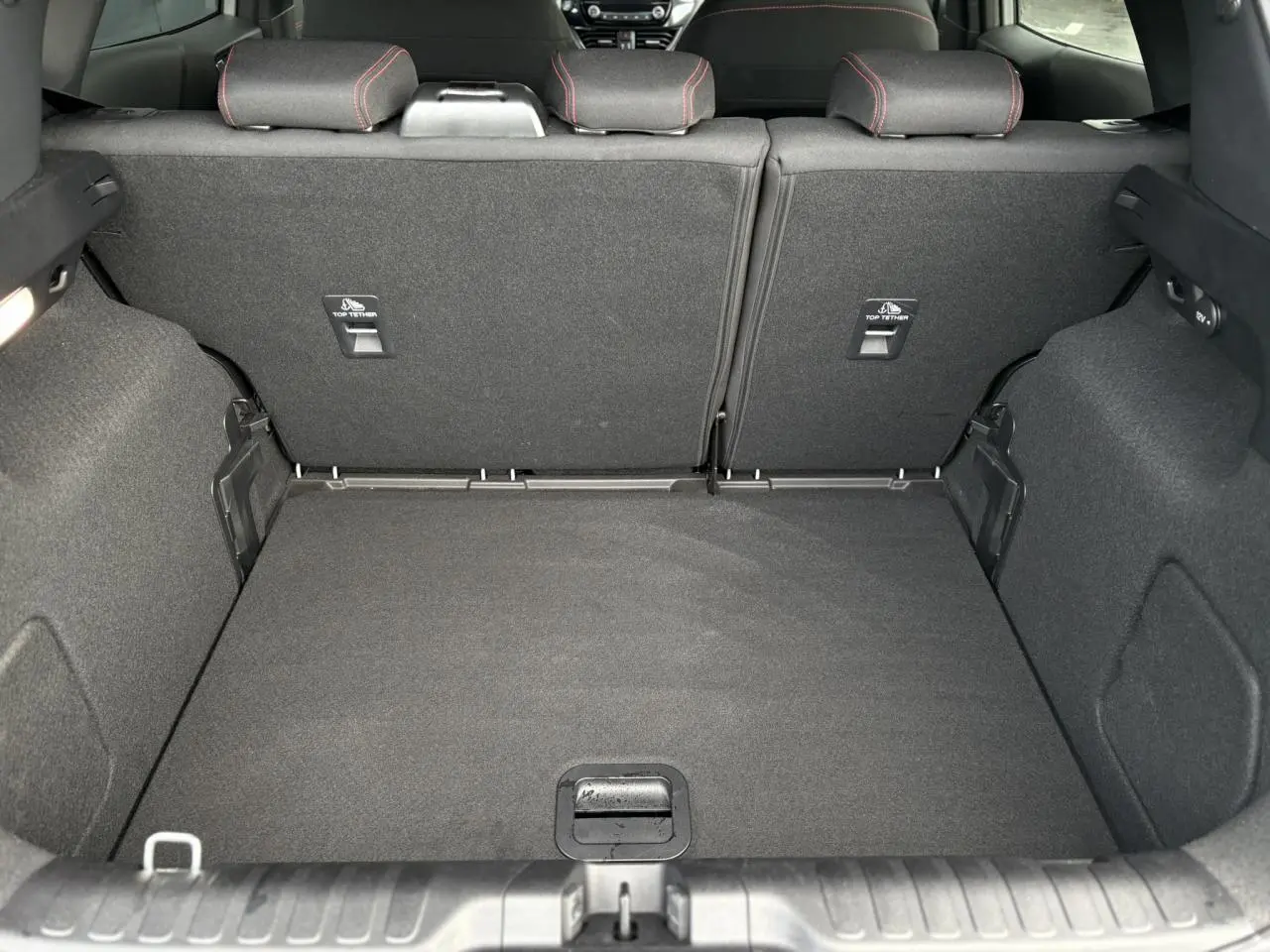 Coffre spacieux vu de l’arrière d’un Ford Puma gris Solar avec sièges arrière rabattus et finitions noires.