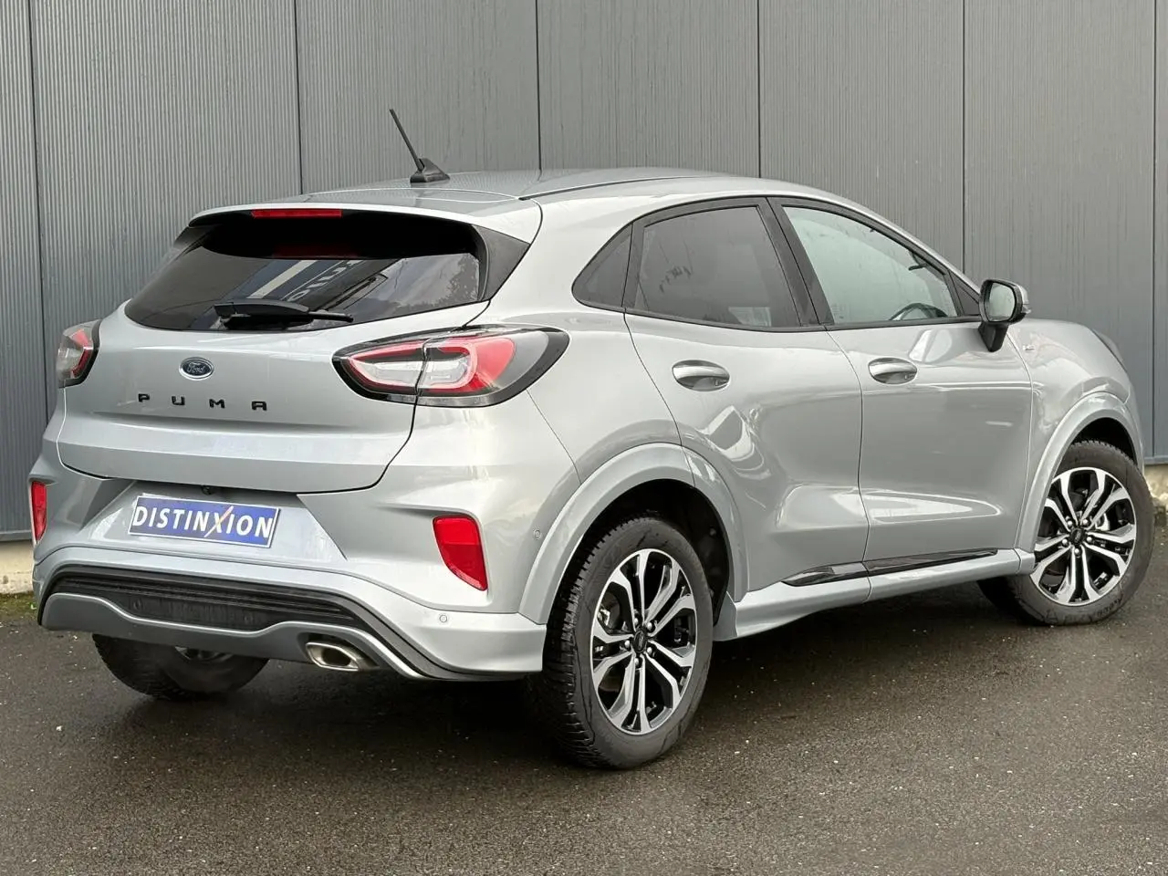 Vue 3/4 arrière droite d'une Ford Puma gris Solar avec jantes alliage 17 pouces et hayon électrique.