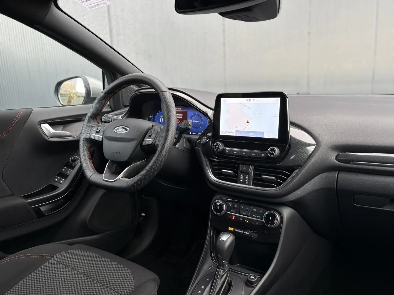 Vue intérieure côté conducteur du Ford Puma 2023, volant ST-Line, écran tactile GPS et console centrale noire.