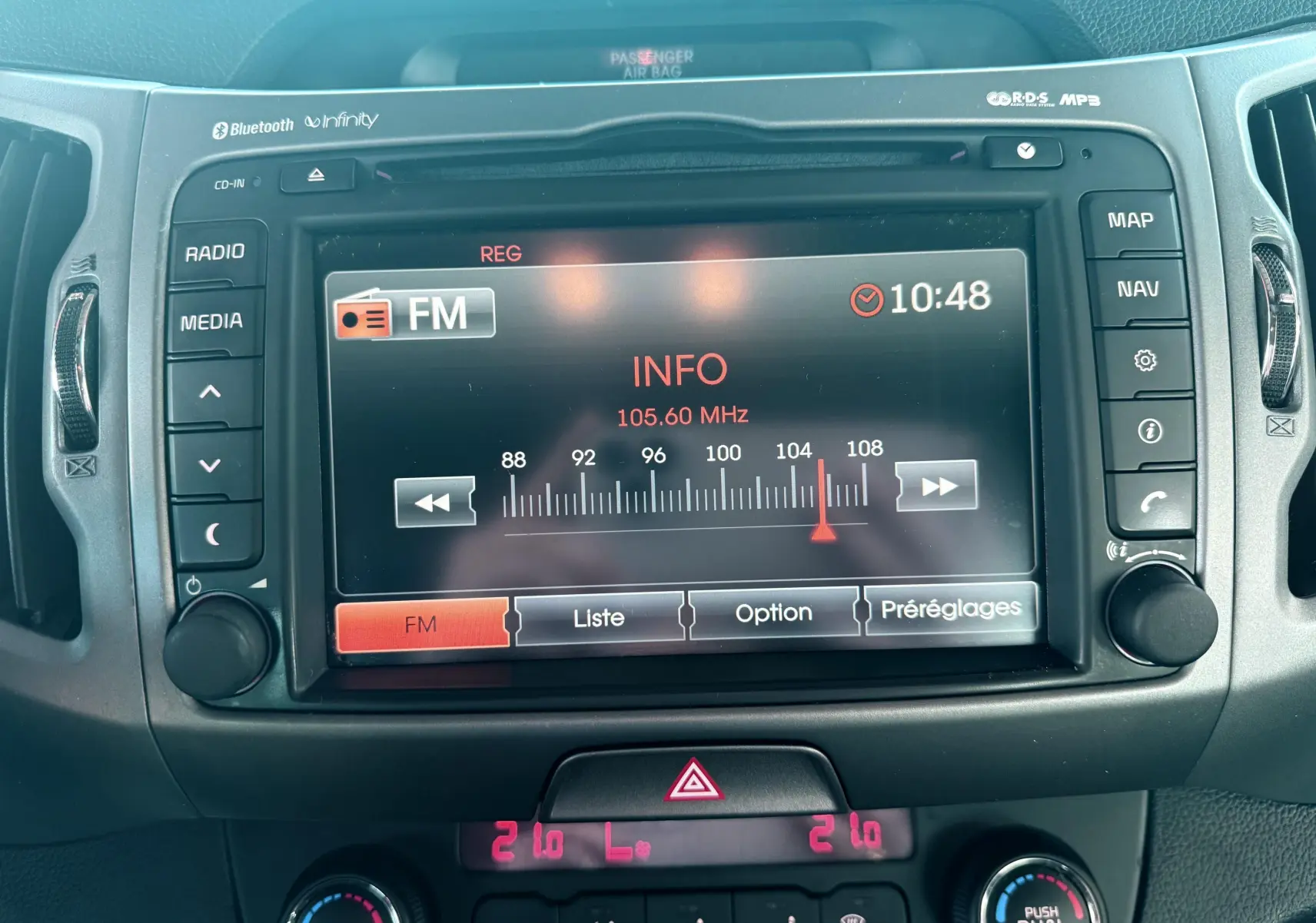 Vue rapprochée de l'écran multimédia et de la console centrale du Kia Sportage 2015, affichant la radio FM.