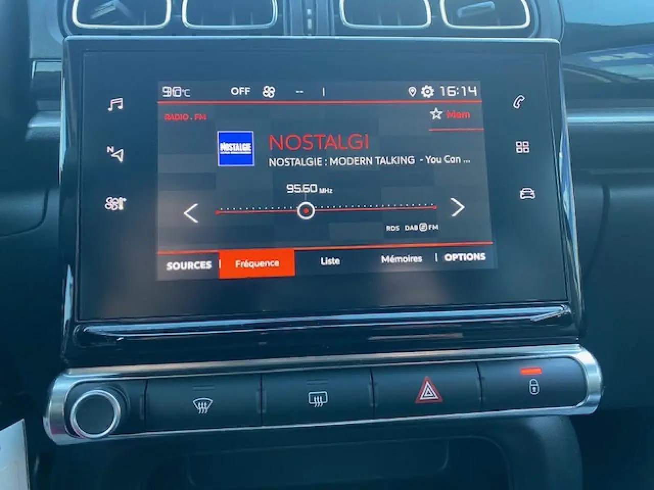 Écran tactile central de la Citroën C3 2023 affichant la radio Nostalgie, avec commandes climatisation et alertes en dessous.