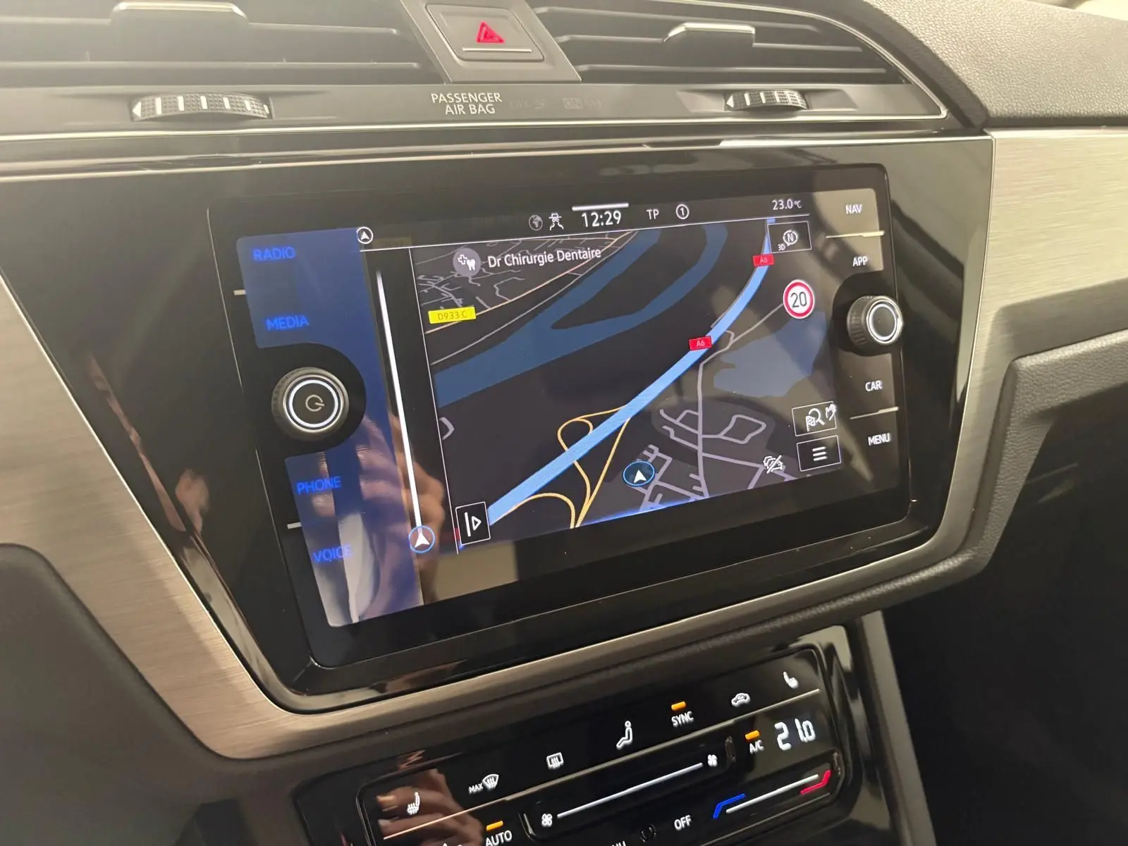 Écran tactile GPS et commandes climatisation du tableau de bord du Volkswagen Touran gris dauphin 2025.