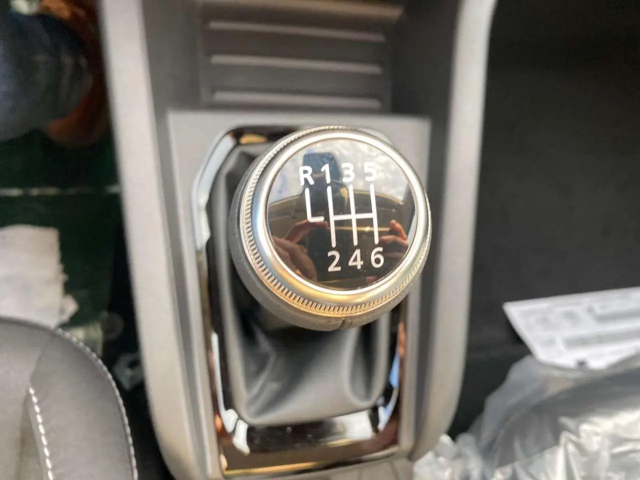 Gros plan sur le levier de vitesses manuel de la Renault Clio 1.5 Blue dCi noir, montrant les six rapports et la marche arrière.