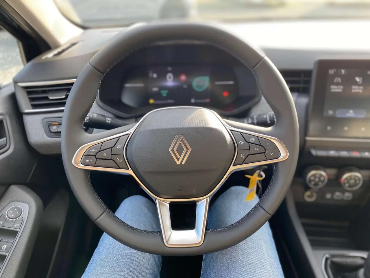 Vue intérieure centrée sur le volant multifonction noir de la Renault Clio 1.5 Blue dCi 2025 avec tableau de bord numérique.