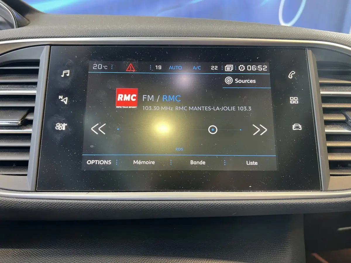Écran tactile central de la Peugeot 308 GT Line 2019 affichant la radio FM RMC à 6h52.