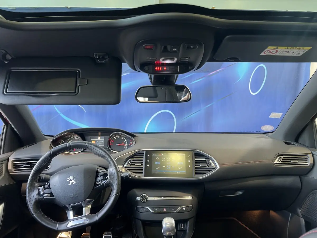 Intérieur avant de la Peugeot 308 GT Line 2019, tableau de bord noir avec écran tactile central et volant cuir multifonctions.