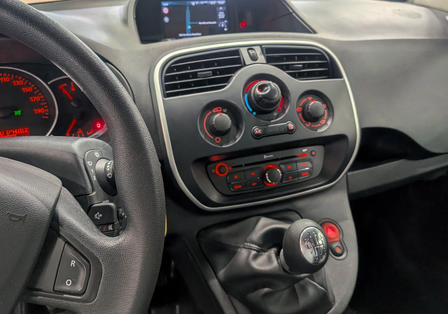 Vue rapprochée de la console centrale et levier de vitesse d'un Renault Kangoo Express gris Highland de 2021.