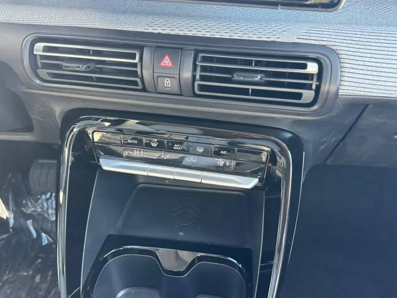 Vue rapprochée de la console centrale noire brillante du Citroën C3 Aircross 2026 avec commandes climatisation et aérateurs.