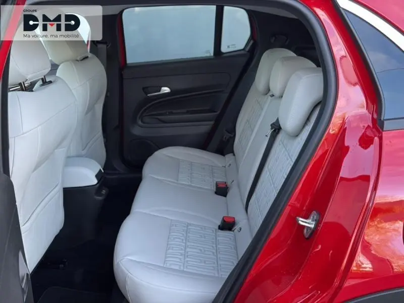 Vue côté droit sur la banquette arrière ivoire du FIAT 600 rouge, avec porte arrière ouverte et détails intérieurs visibles.