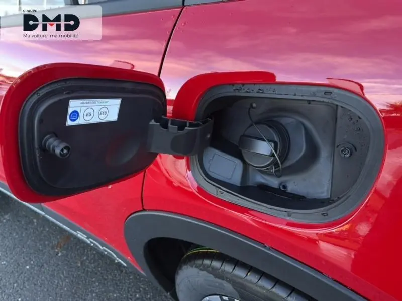 Trappe de carburant ouverte côté gauche sur FIAT 600 rouge, montrant le bouchon essence hybride.