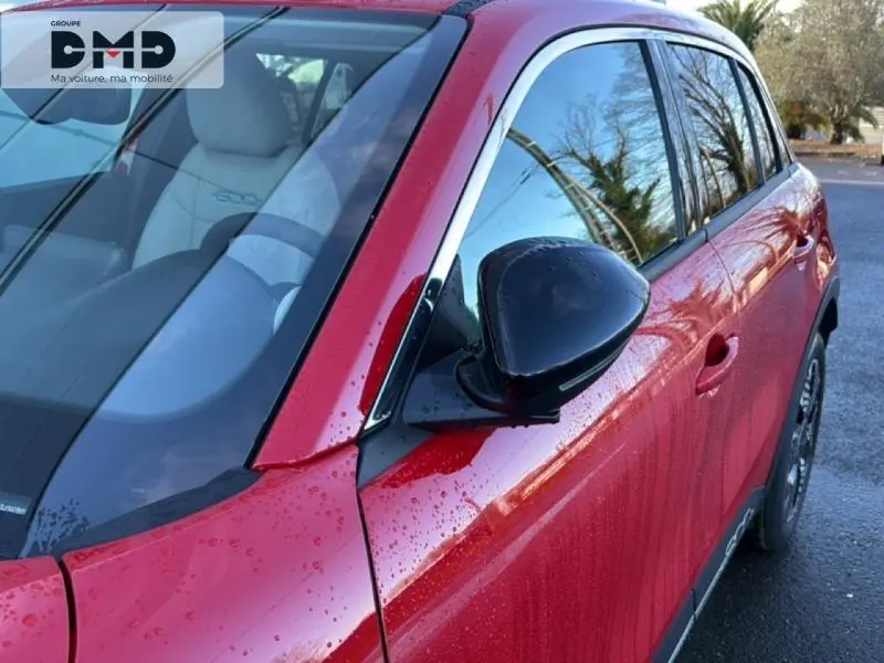 Vue côté droit avant d'une FIAT 600 rouge 2026 avec rétroviseur noir et vitres teintées.