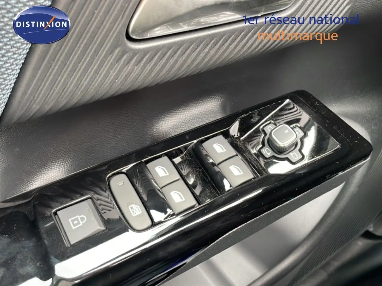 Gros plan sur les commandes de lève-vitres et réglage des rétroviseurs côté conducteur d'une Citroën C5 Aircross noir perle métal.