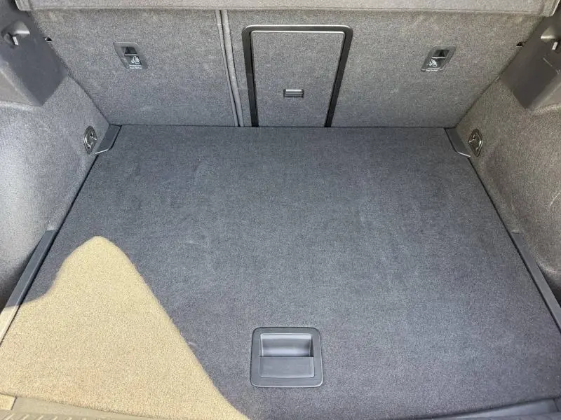 Vue plongeante sur le coffre spacieux et tapissé de tissu gris du CUPRA Formentor 1.5 eTSI Hybrid 2025 Noir Minuit métallisé.