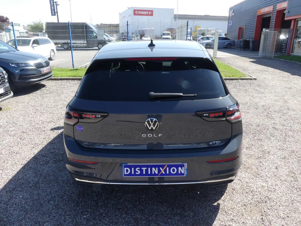 Vue arrière d'une Volkswagen Golf 1.5 eTSI grise métallisée avec vitres arrière surteintées et feux LED défilants.