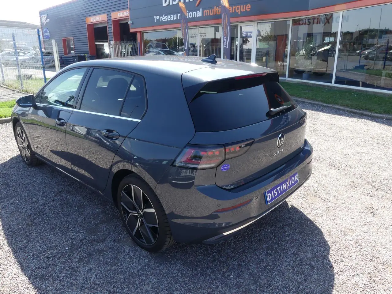 Vue 3/4 arrière droite d'une Volkswagen Golf 1.5 eTSI Style 2024 gris métallisé avec jantes alliage et vitres surteintées.
