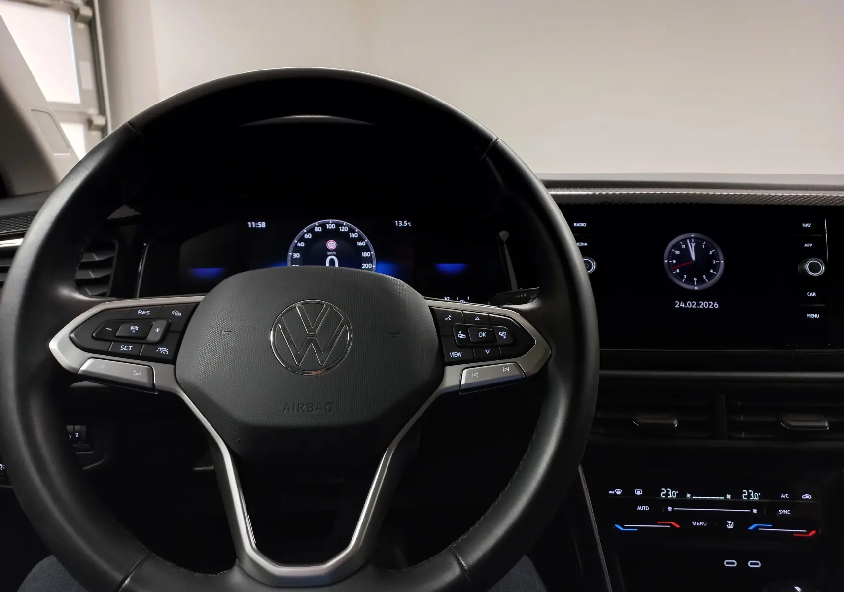 Vue intérieure centrée sur le volant noir de la Volkswagen Taigo 2025 avec tableau de bord digital et écran tactile.