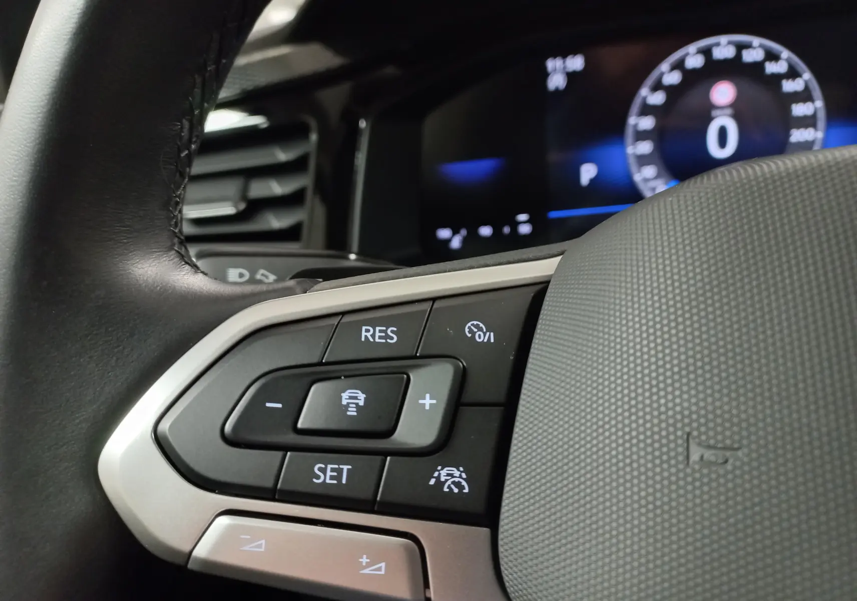 Gros plan sur les commandes du volant du Volkswagen Taigo 2025, boutons de régulateur de vitesse et assistance conduite visibles.