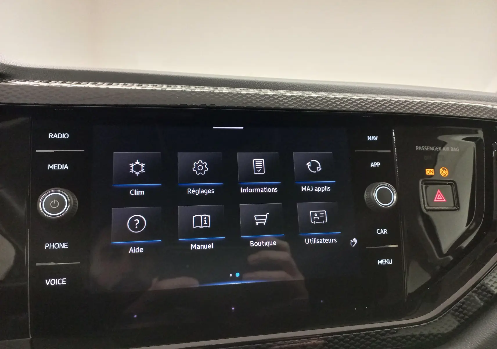 Écran tactile central du Volkswagen Taigo 2025 affichant les options climatisation, réglages et informations, entouré de commandes physiques.