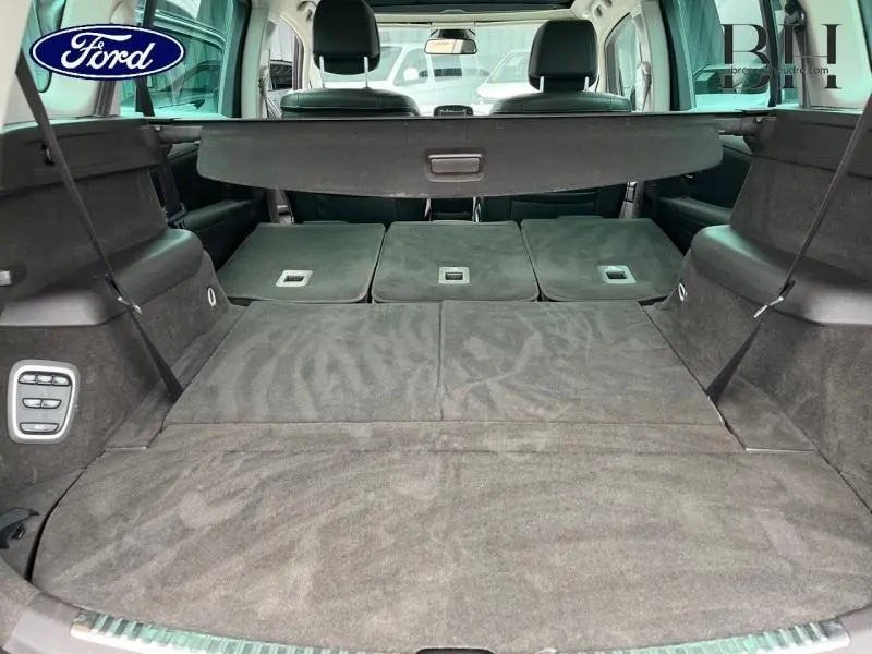 Vue du coffre arrière ouvert d'un Renault Espace gris Cassiopée, montrant les sièges arrière rabattus et la tablette cache-bagages.