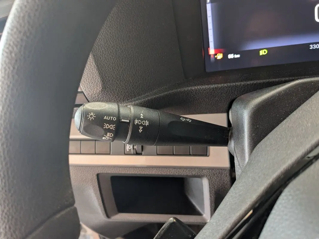 Gros plan sur le commodo d'éclairage à gauche du volant dans l'habitacle du Fiat Scudo Fourgon blanc 2025.