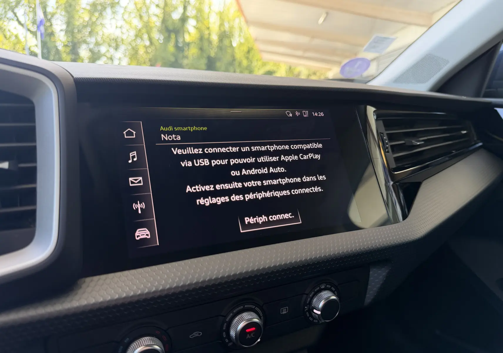 Vue intérieure de l'Audi A1 Sportback 2020, écran central affichant la connexion smartphone, détails du tableau de bord noir.