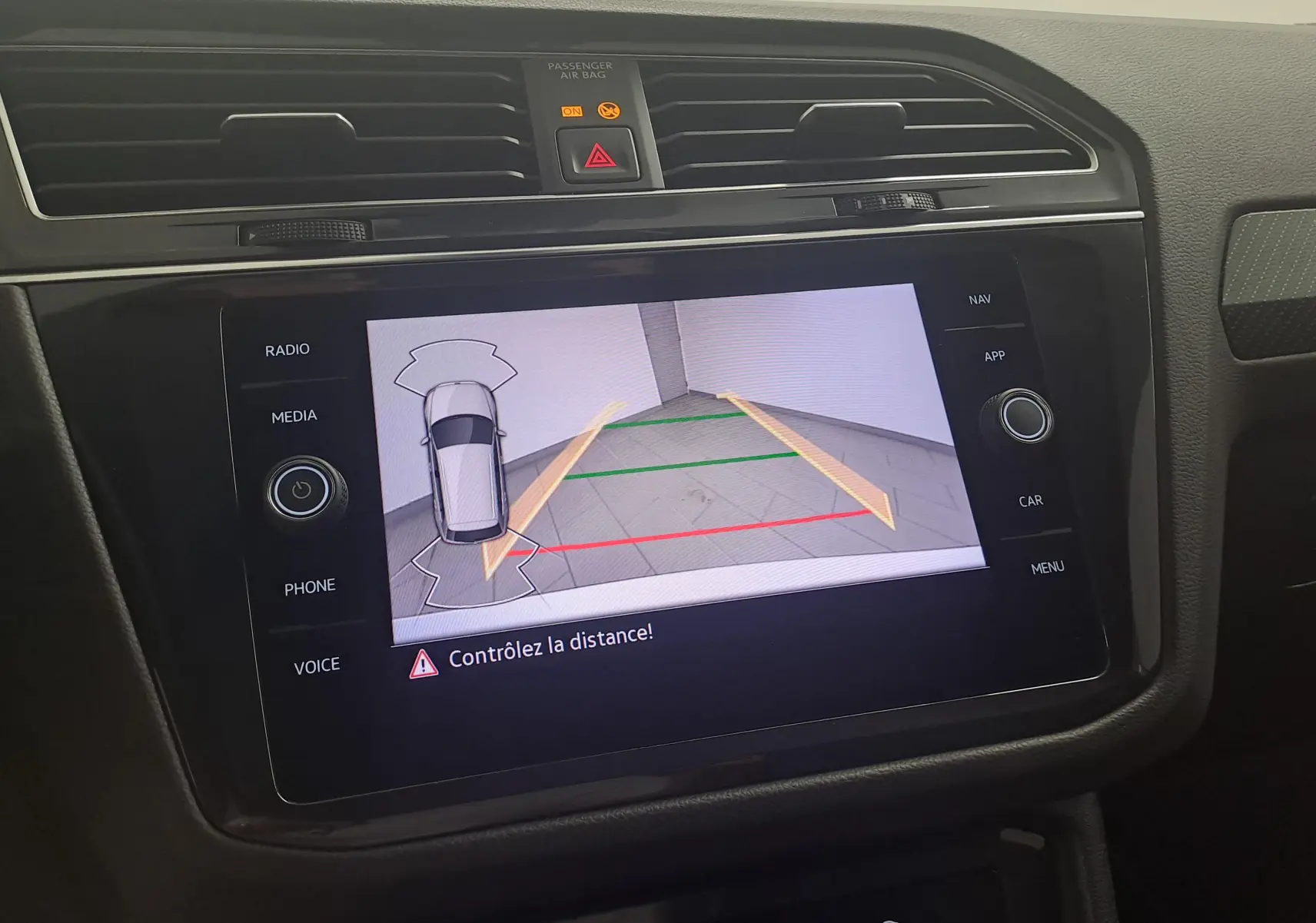 Écran central du Volkswagen Tiguan 2023 blanc pur montrant la caméra de recul avec guidage dynamique.