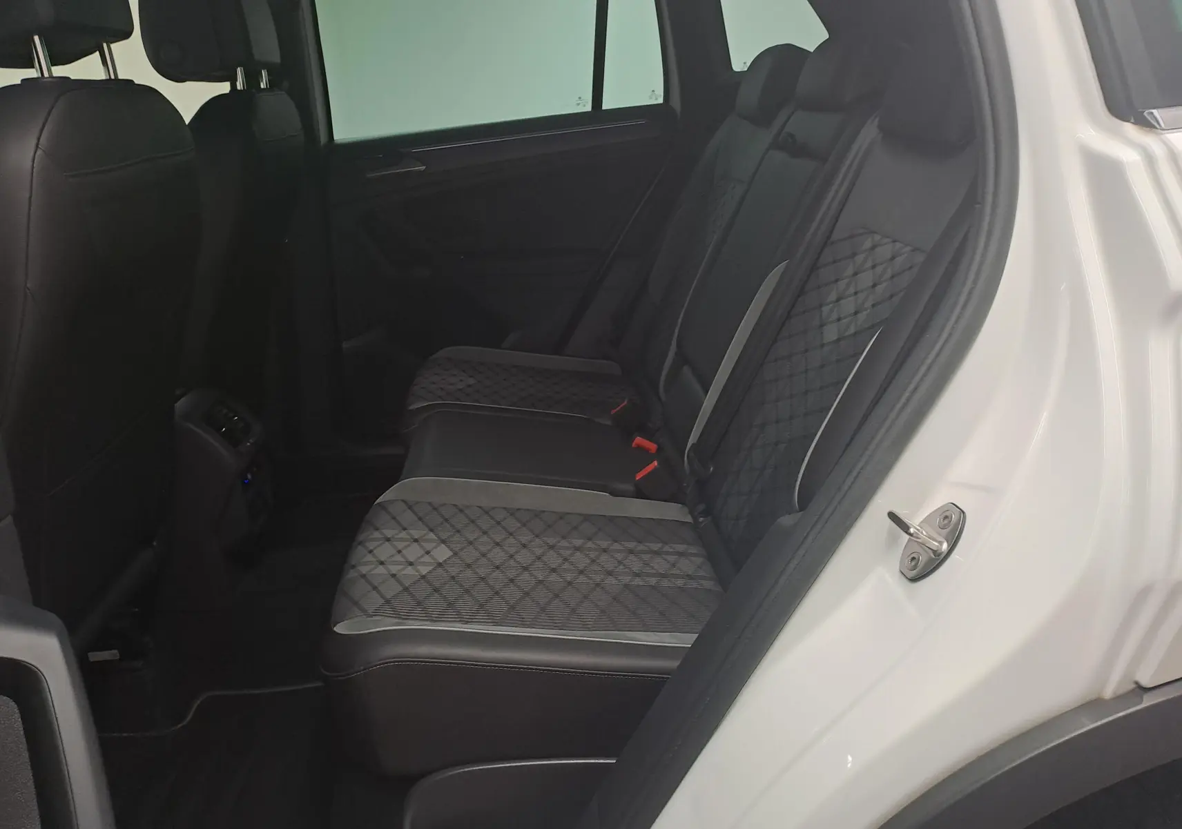 Vue intérieure côté droit sur les sièges arrière en tissu et cuir du Volkswagen Tiguan blanc pur 2023 R-Line hybride rechargeable.
