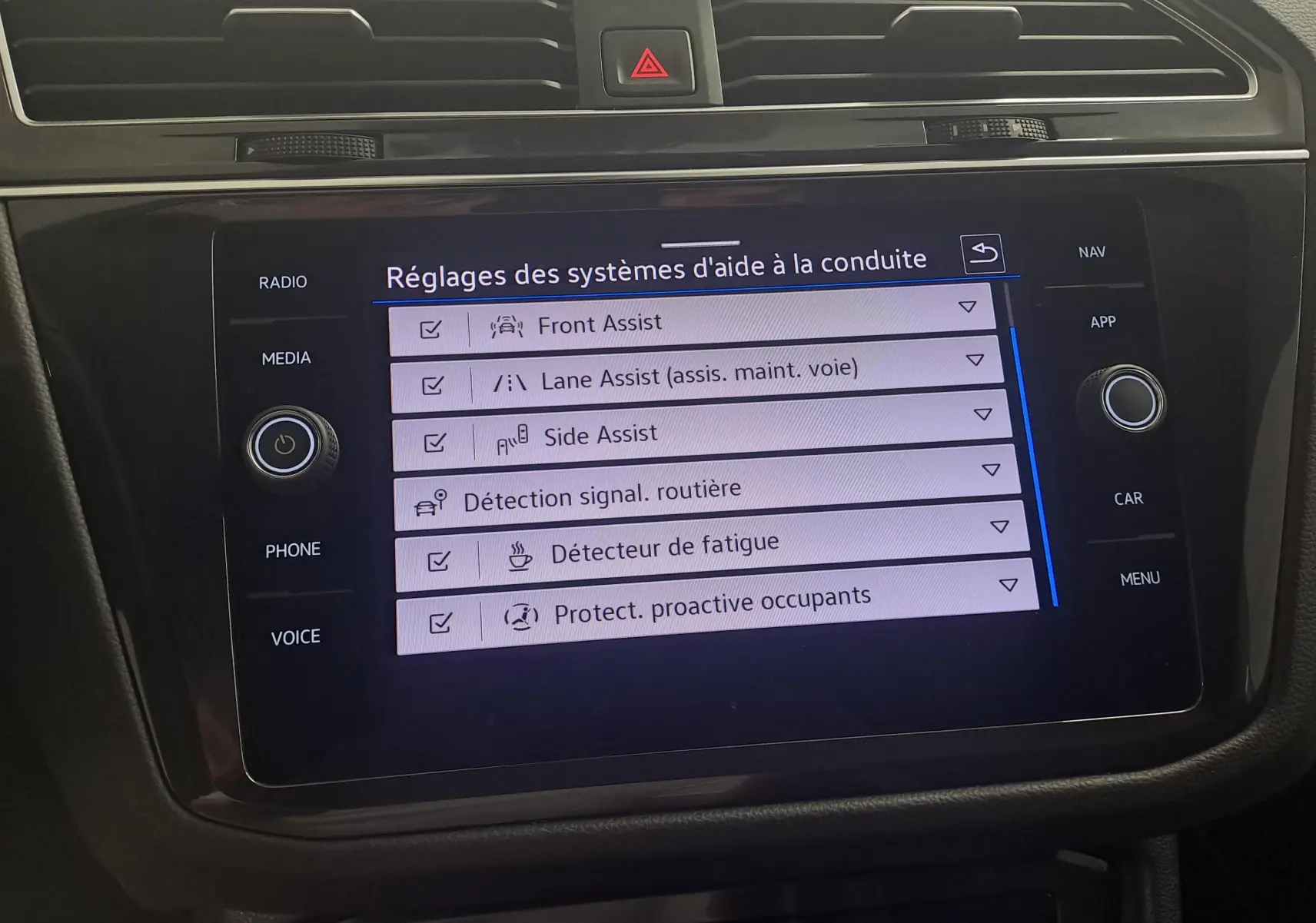 Écran tactile central du Volkswagen Tiguan 1.4 eHybrid 2023 affichant les réglages des aides à la conduite.