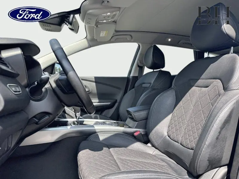 Intérieur avant du Renault Kadjar 2019, sièges noirs en tissu et cuir avec accoudoir central et volant multifonction.