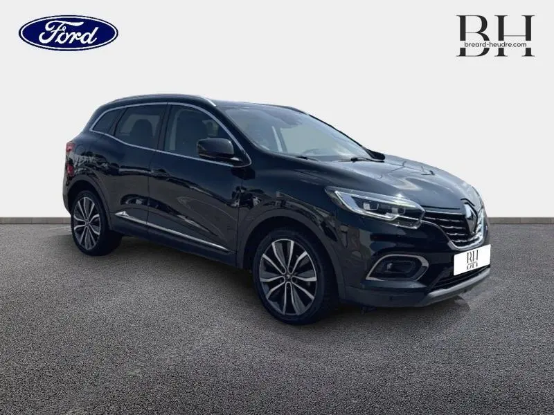 Renault Kadjar noir étoilé en 3/4 avant droit, avec toit en verre fixe et jantes alliage visibles.