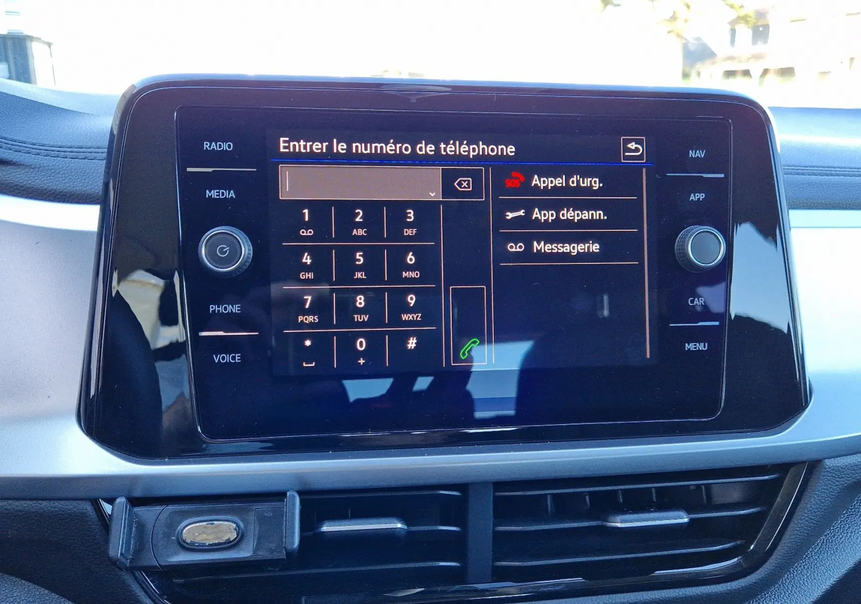 Écran tactile central du Volkswagen T-Roc 2023 affichant le clavier pour entrer un numéro de téléphone, avec options d'appel d'urgence et messagerie.