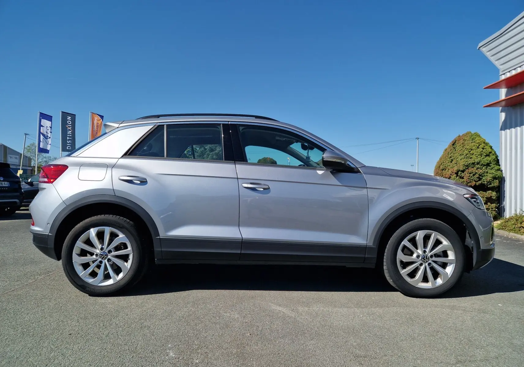 Profil côté droit d'un Volkswagen T-Roc gris pyrite 2023, mettant en valeur ses jantes alliage et sa silhouette compacte.