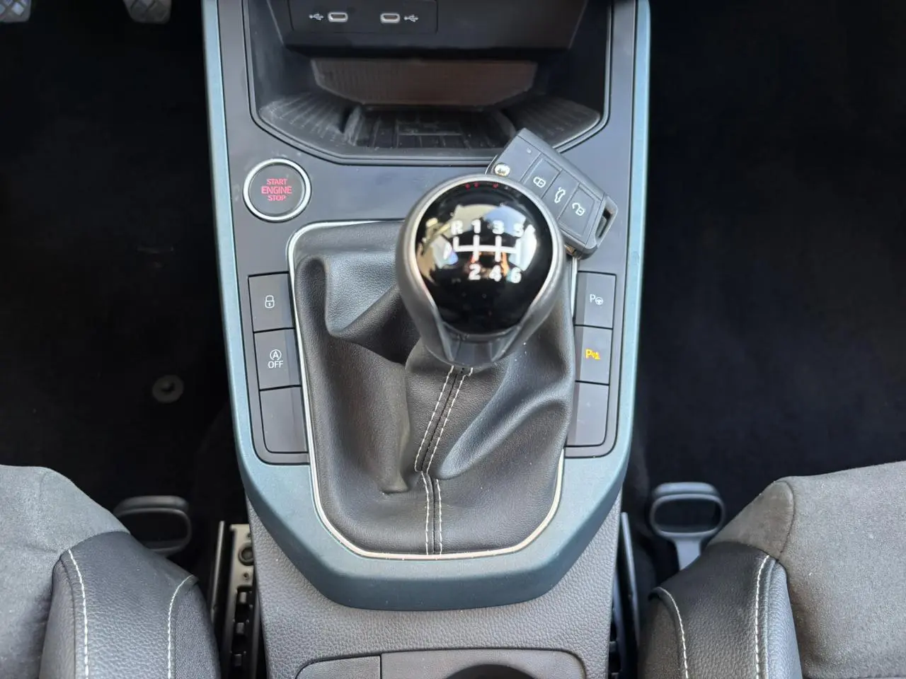 Gros plan sur la console centrale du SEAT Arona TSI 115 Xpérience 2025 avec levier de vitesses manuel et clé posée dessus.